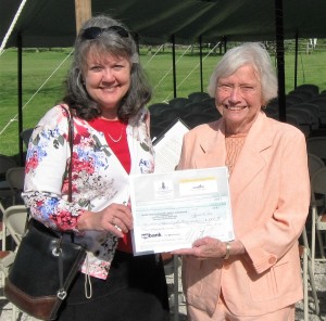 LIWLRA Board Member and Laurapalooza Auction Organizer Connie Neumann presents a $1000 donation to Mrs. Jean Coday, Director Laura Ingalls Wilder Historic Home & Museum.