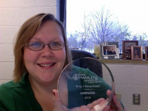 Amy Lauters displays the award given to LauraPalooza by the Greater Mankato Convention and Visitors Bureau.